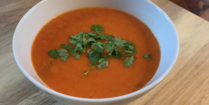 Tomato soup in a bowl garnished with herbs